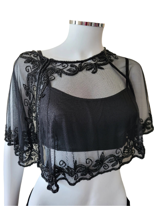 Black sequins embellished capelet displayed on a mannequin, featuring a net design with a touch of iron.
