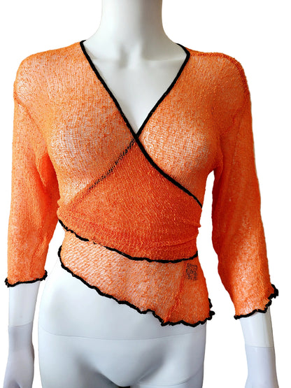 Orange knit top with black trim on a mannequin against a beige background