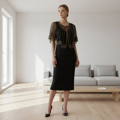 Side view of black sheer capelet with gold embellishments and a scalloped edge.