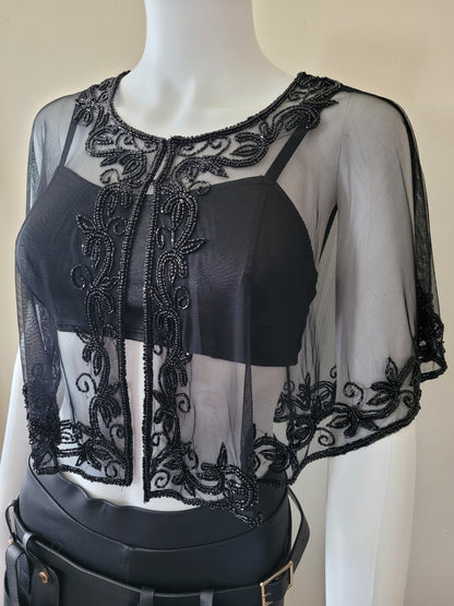 poncho with beads in black, the material is transparent with  floral design all around collar and bottom .